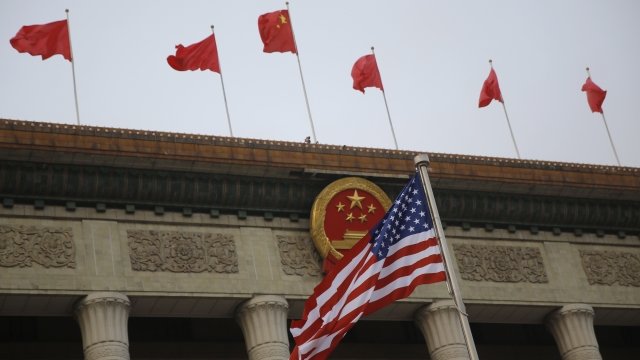 An American Flag waves next to the Flag of China