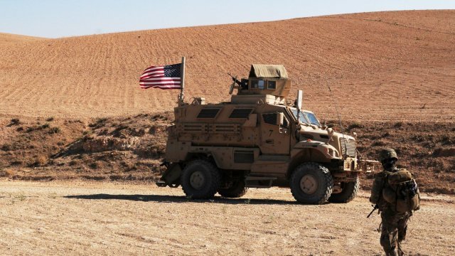 A U.S. Soldier walks toward a tactical vehicle used to provide security during a patrol outside Manbij, Syria.