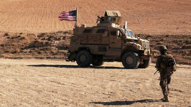 A U.S. soldier walks toward a tactical vehicle in Syria