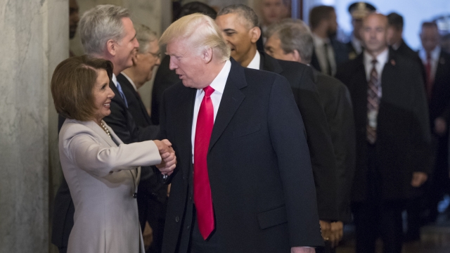 Nancy Pelosi and Donald Trump shake hands.