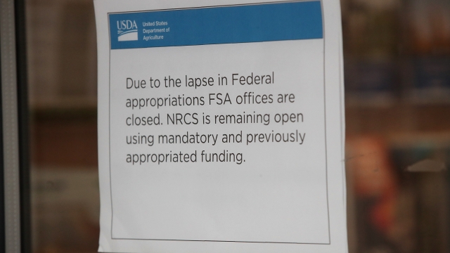 A sign on the door of the USDA office announces the Farm Service Agency is closed.