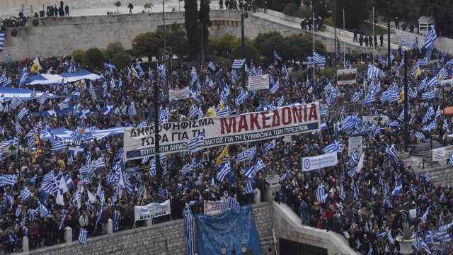 Demonstrators hold Greek flags during a rally.