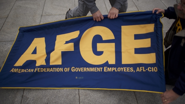 People set up an American Federation of Government Employees a banner