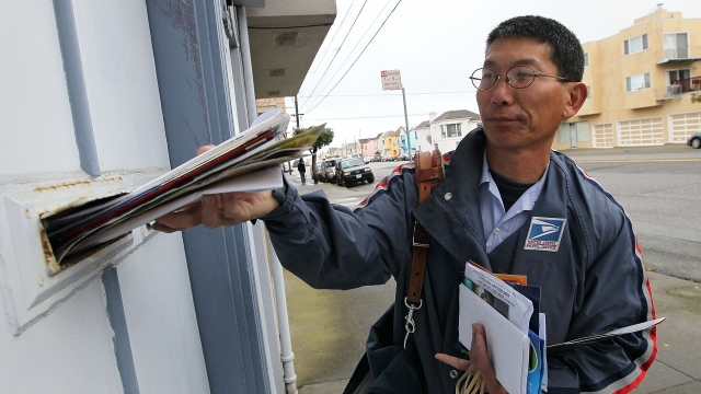 A U.S. Postal Service employees delivers mail
