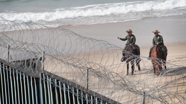 Border Patrol agents stand at the border wall separating the United States from Tijuana, Mexico in January 2019
