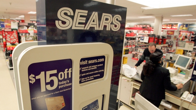 A cashier rings up a customer at a Sears store