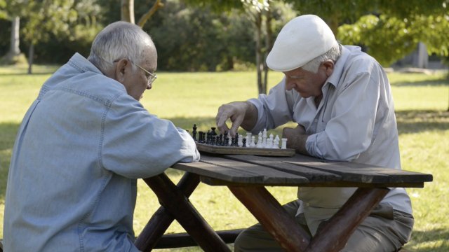 Two men play chess outdoors