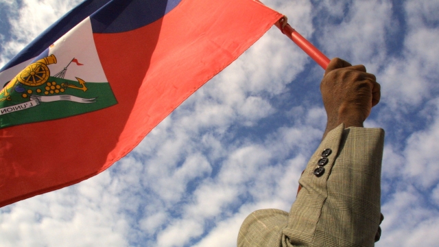 Man holds a Haitian flag in the air