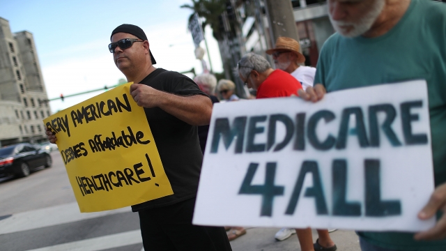 Protesters hold signs supporting "Medicare for all"