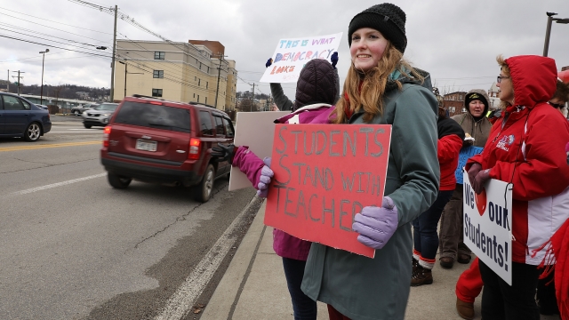 Students and supporters of West Virginia teachers hold up signs