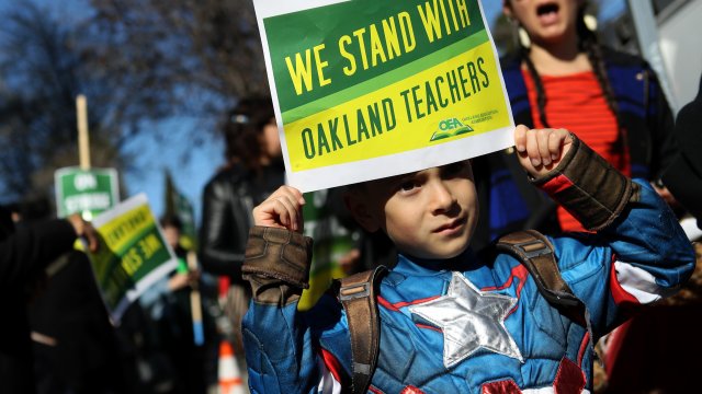 Boy holds sign supporting Oakland teachers