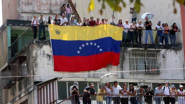 People display a Venezuelan flag on a balcony