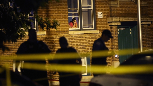 A woman watches as police look for evidence