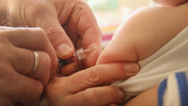 A doctor injects a vaccine against measles into a patient