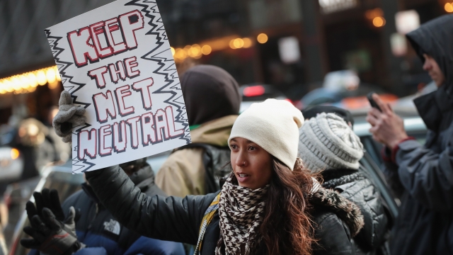 A demonstrator protests the Federal Communications Commission outside a Verizon store in Chicago, Illinois