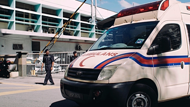 Police officers guard the entrance of the forensic department of Kuala Lumpur General Hospital.