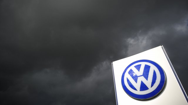 Rain clouds are seen over a Volkswagen symbol at the main entrance gate at Volkswagen production plant.