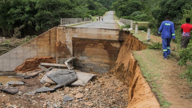 People cross one of several bridges destroyed by Cyclone Idai.