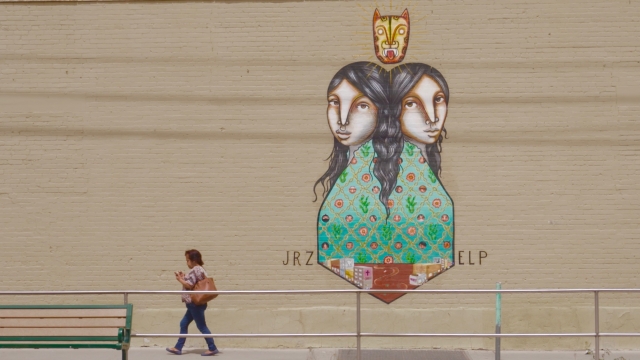 A woman walks by a mural in downtown El Paso.