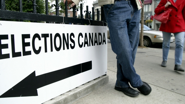 People enter a polling station to vote in Canada during a 2004 federal election