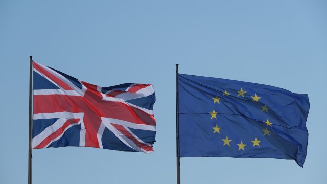 The European Union and British flags fly.