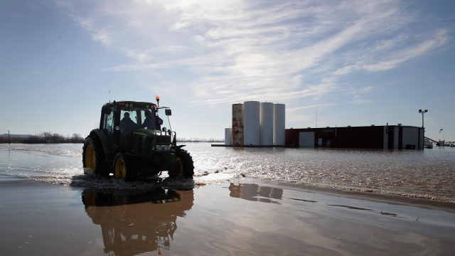 A tractor moves along flooded Highway 59 on March 22, 2019 near Craig, Missouri