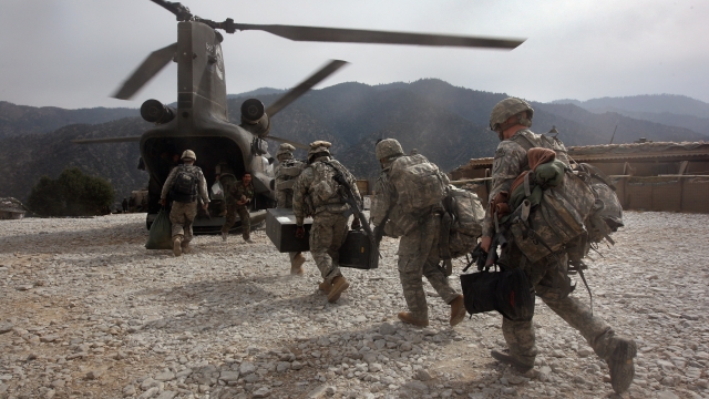 U.S. troops run toward a helicopter