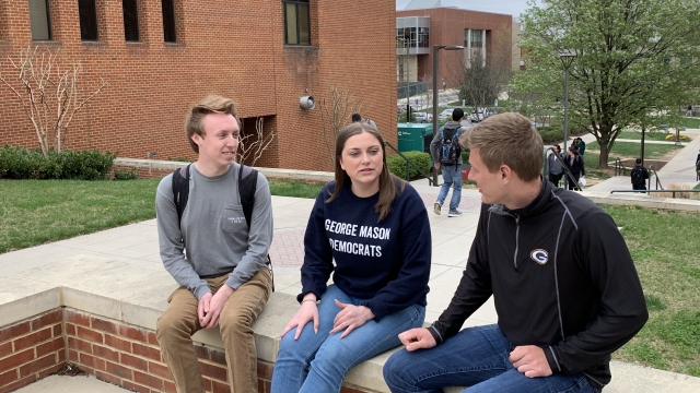 Three students sit and talk on the campus of George Mason University in Virginia.