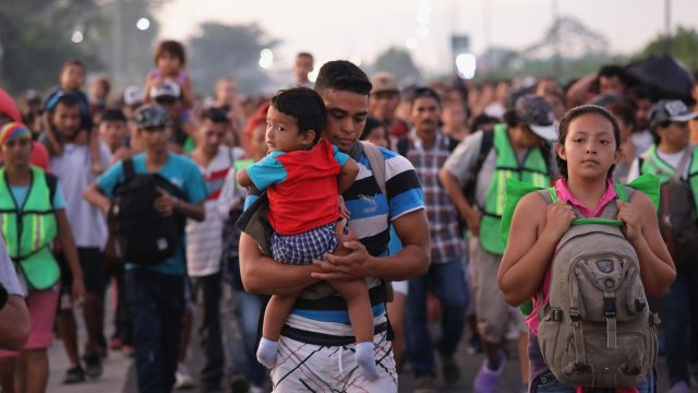 Migrants walk towards camera