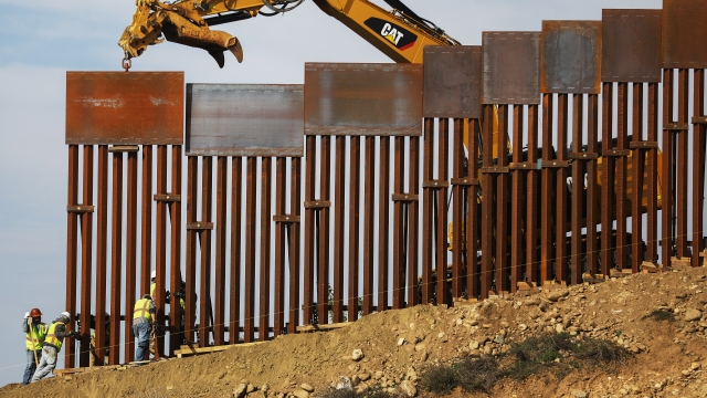 A construction crew installs new border barriers