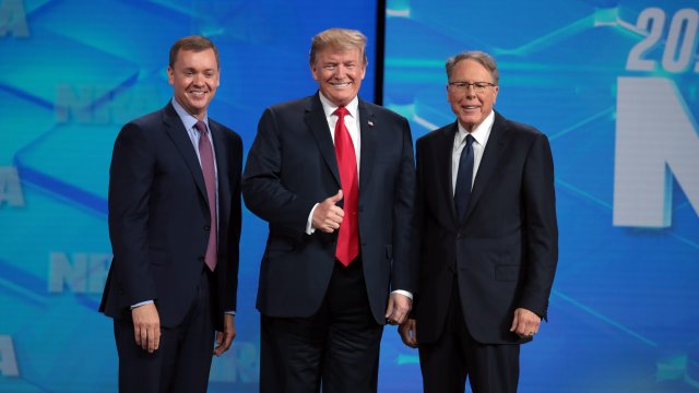 President Trump stands on stage along with NRA executives at the annual NRA Leadership Forum