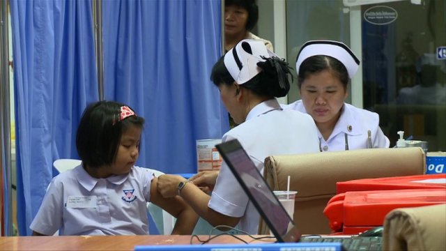 A nurse administers the Dengvaxia vaccine to a young girl