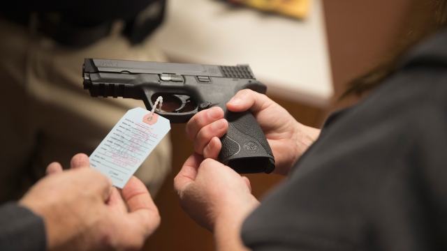 A person holds a handgun in a store