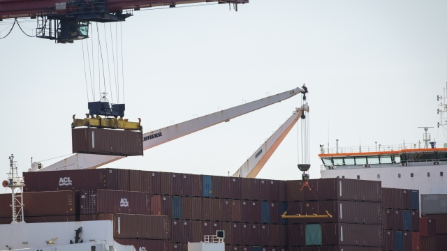 A shipping container is loaded onto a cargo ship