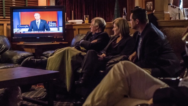 A group of people watch a Fox News nightly report
