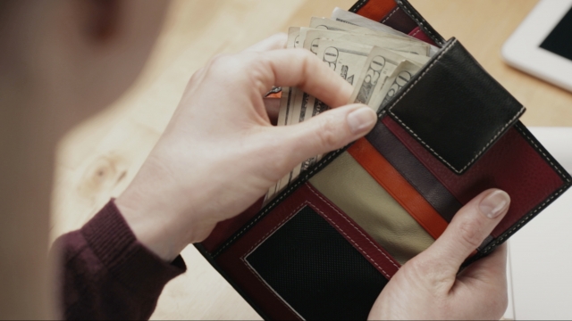 Woman looks through her wallet
