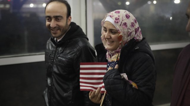 Syrian refugee holds an American flag