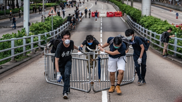 Protesters move a barricade on an expressway next to the Hong Kong Police Headquarters on June 21, 2019