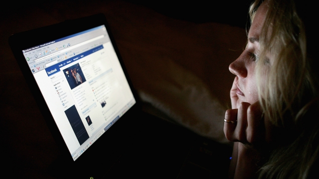 A woman browses Facebook