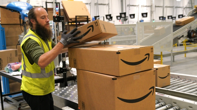 A man stacks Amazon boxes