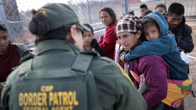 A Border Patrol agent takes Central American immigrants into custody