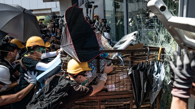Protesters use a makeshift battering ram to break into the Legislative Council building