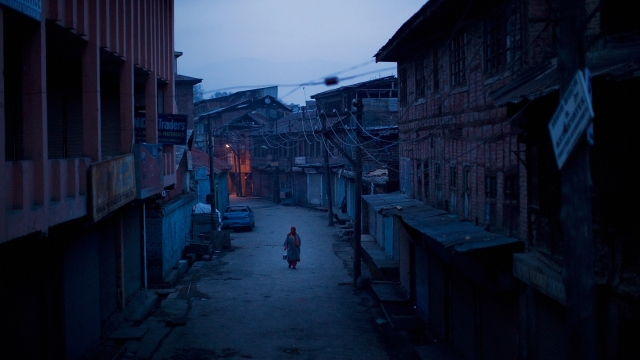A woman walks down a street in Kashmir