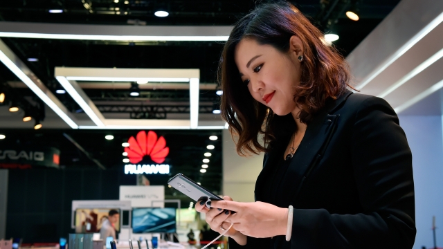 A woman looking at a Huawei smartphone