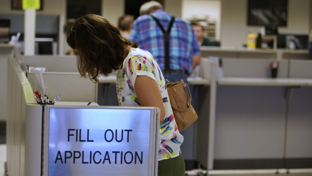 People fill out a driver license application at the DMV