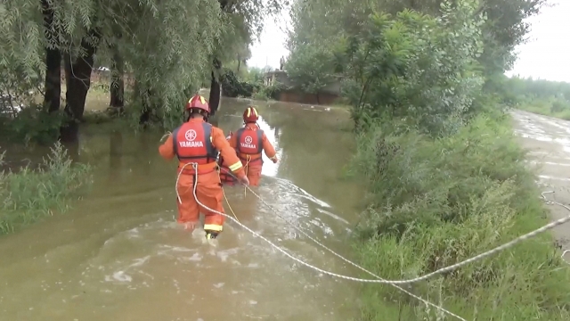 Rescue workers wade through water after Typhoon Lekima hit eastern China.