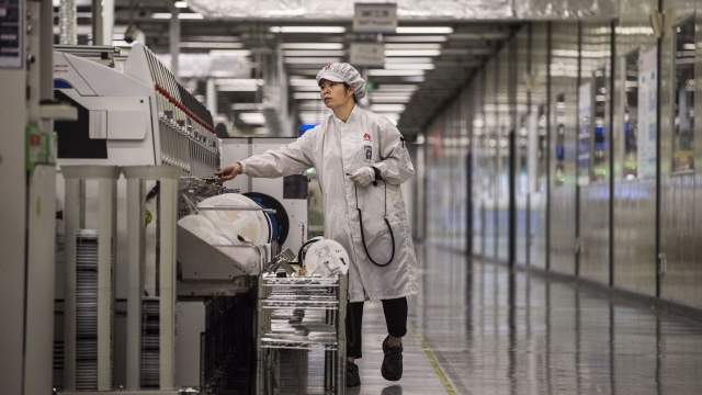 A worker packs up new smartphone devices at the end of the production line at Huawei's production campus