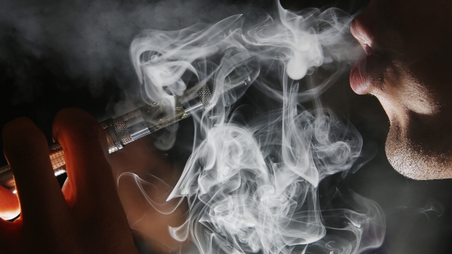 A man smokes an E-Cigarette at the V-Revolution E-Cigarette shop in Covent Garden on August 27, 2014 in London, England.
