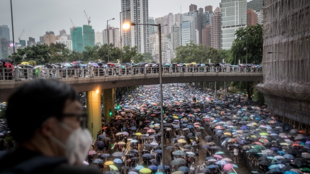 A man watches thousands of anti-government protestors leave a rally in Victoria Park on August 18, 2019 in Hong Kong, China.