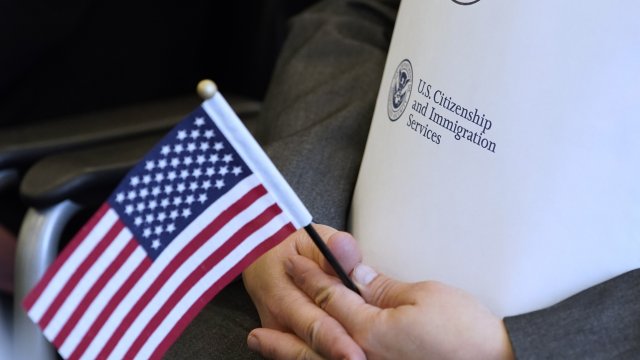 Person holds an American flag and immigration documents